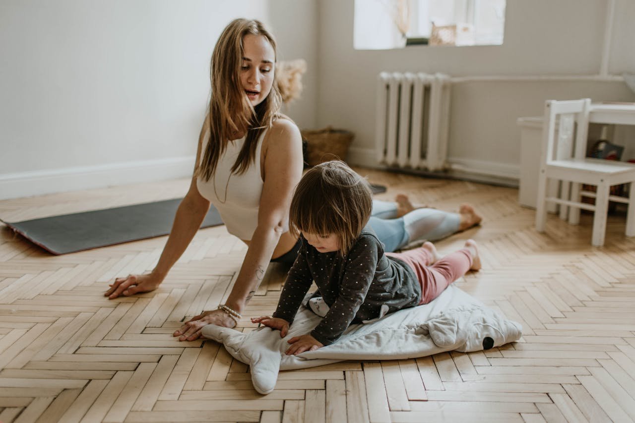 services-01 A mother and child practicing yoga together at home on a sunny day, fostering wellness and connection.